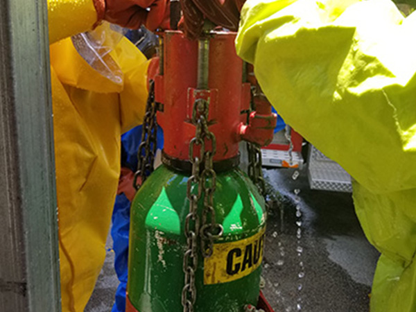 hazmat-resized-caution-tank Hamzat technicians managing dangerous item.